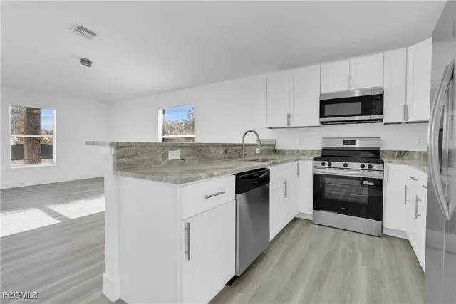 a kitchen with stainless steel appliances granite countertop a stove sink and microwave