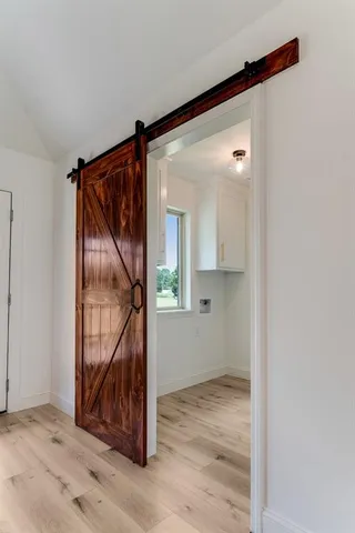 a view of an empty room with wooden floor and a wall painting