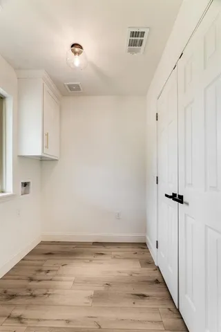 a view of a room with wooden floor and cabinets