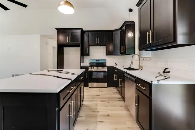 a kitchen with stainless steel appliances a sink stove and cabinets