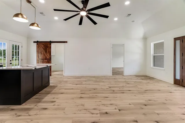 a view of a kitchen with kitchen island a sink wooden floor and a window