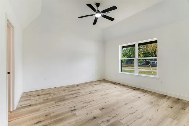 a view of a room with wooden floor and a window