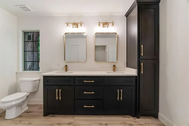 a bathroom with a toilet sink and mirror