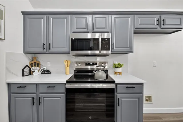 a kitchen with granite countertop a sink stove and cabinets