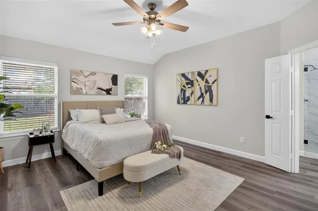 a spacious bedroom with a bed and wooden floor