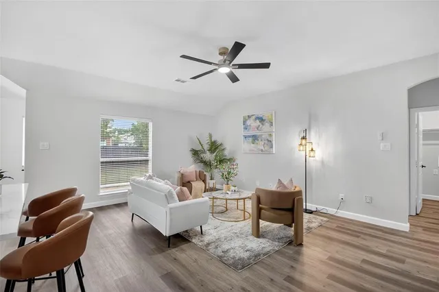 a living room with furniture and a wooden floor