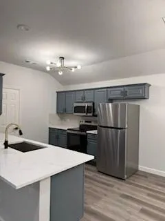 a kitchen with kitchen island a sink appliances and cabinets
