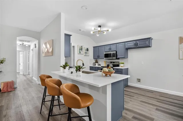 a view of kitchen with sink refrigerator dining table and chairs