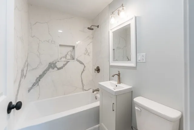 a white bath tub sitting next to a white toilet and a sink