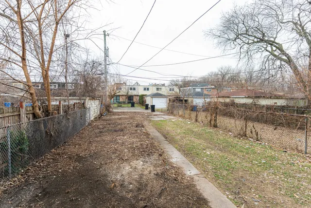 a view of a yard with wooden fence