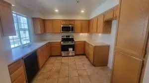 a kitchen with stainless steel appliances a sink a stove a refrigerator a window