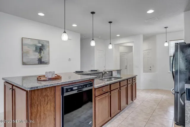 a kitchen with stainless steel appliances granite countertop a sink a stove and a wooden floors