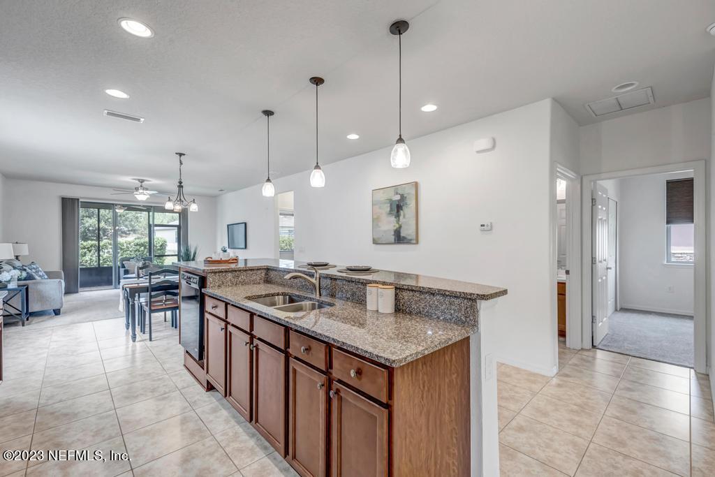 265 Caspia Lane Ponte Vedra, FL 32081 - Photo 12 of 86 a kitchen with a stove a kitchen island a sink and chairs