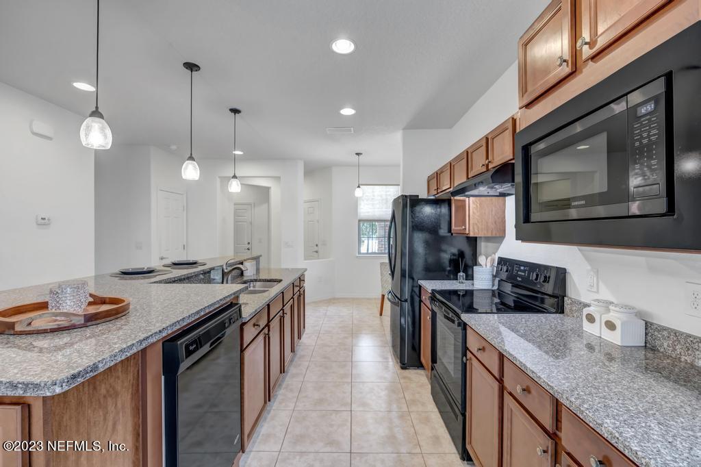 265 Caspia Lane Ponte Vedra, FL 32081 - Photo 14 of 86 a kitchen with stainless steel appliances granite countertop a sink a stove and a wooden floors