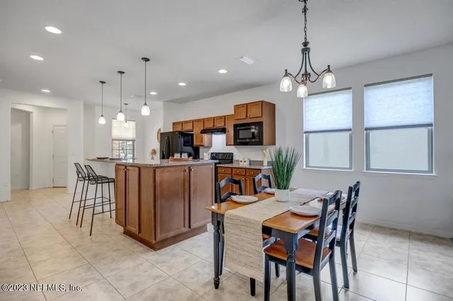 a living room with furniture kitchen view and a chandelier