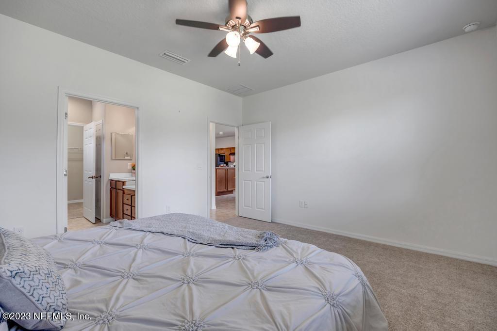 265 Caspia Lane Ponte Vedra, FL 32081 - Photo 25 of 86 a bedroom with a bed and a chandelier