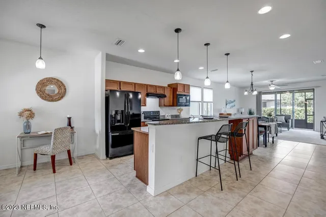 a kitchen with a stove a kitchen island a sink and chairs