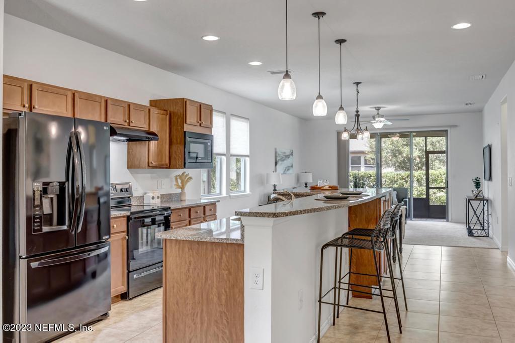 265 Caspia Lane Ponte Vedra, FL 32081 - Photo 10 of 86 a kitchen with stainless steel appliances granite countertop a sink a stove a refrigerator cabinets and chairs