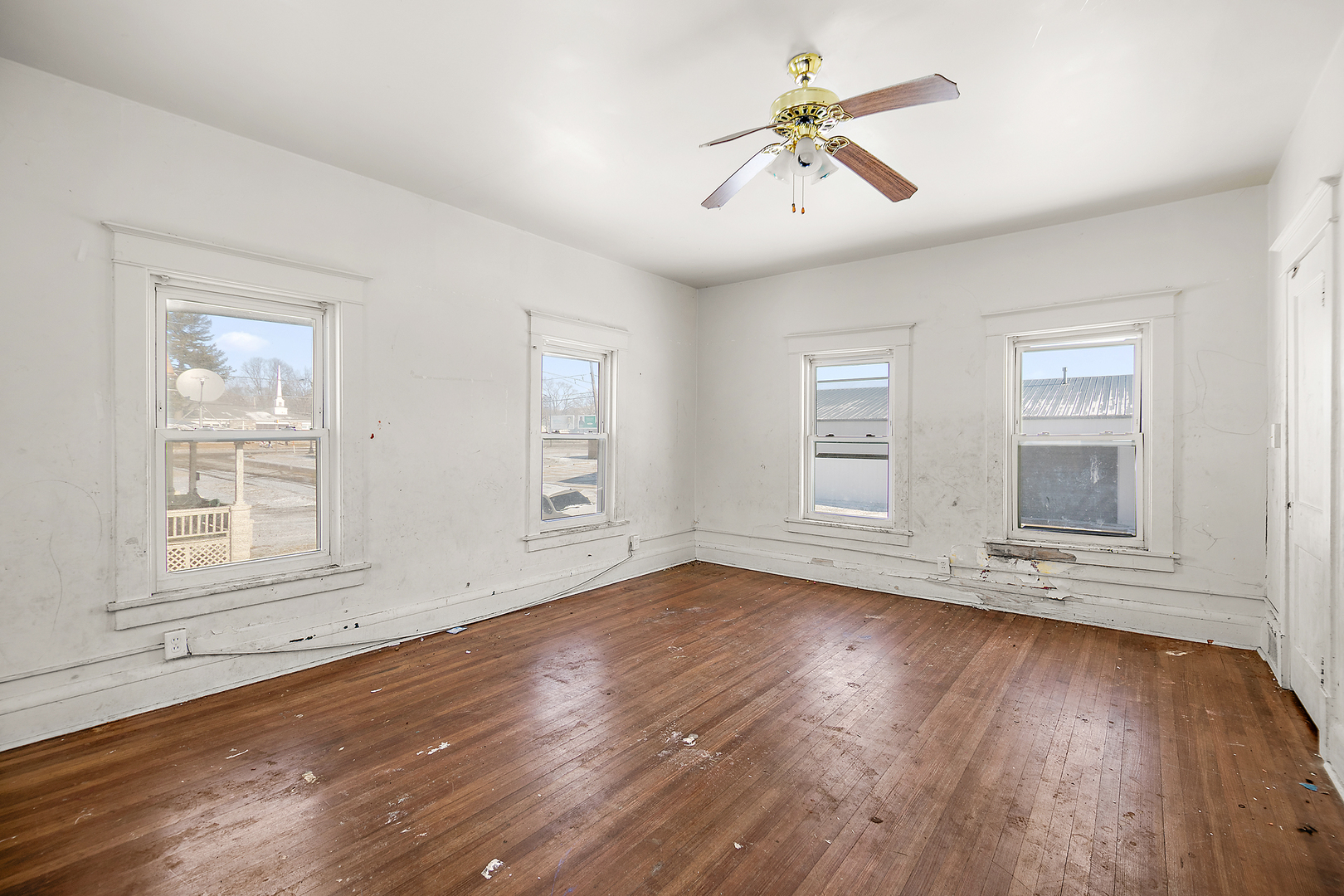 1295 East Merchant Street Kankakee, IL 60901 - Photo 14 of 17 an empty room with wooden floor chandelier fan and windows