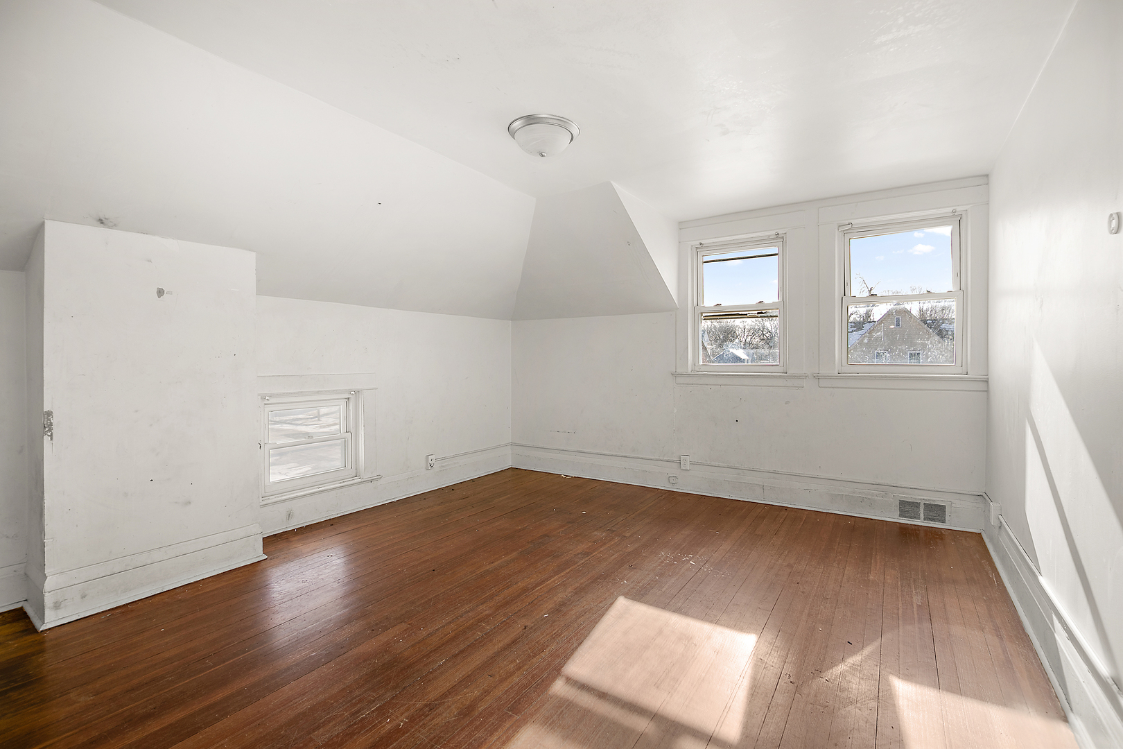 1295 East Merchant Street Kankakee, IL 60901 - Photo 5 of 17 an empty room with wooden floor and windows