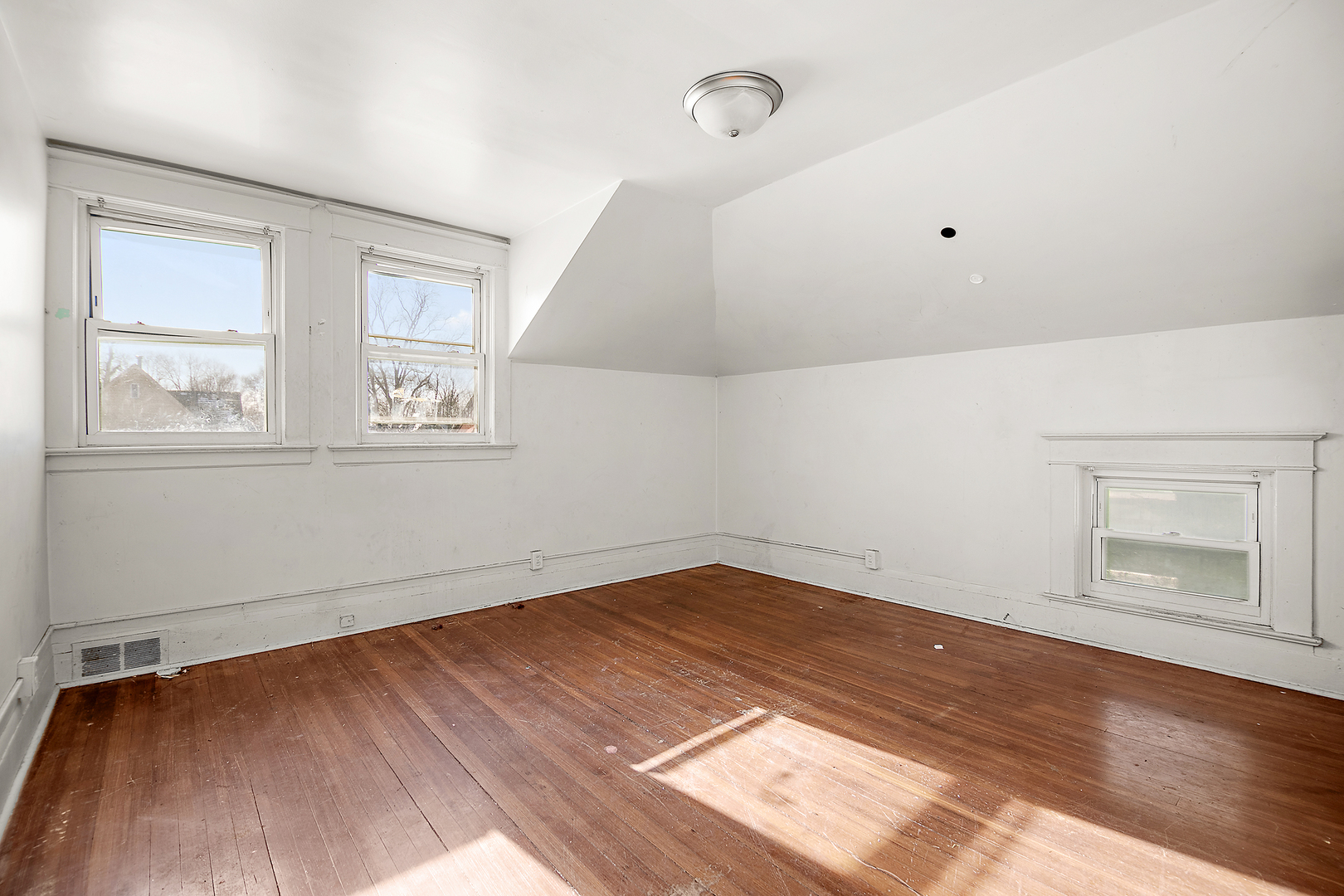 1295 East Merchant Street Kankakee, IL 60901 - Photo 6 of 17 an empty room with wooden floor and windows