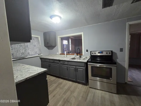 a kitchen with stainless steel appliances kitchen island granite countertop a stove a sink and a microwave