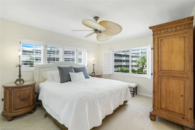 a spacious bedroom with a large bed and a chandelier