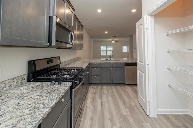 a kitchen with stainless steel appliances granite countertop a stove and a sink