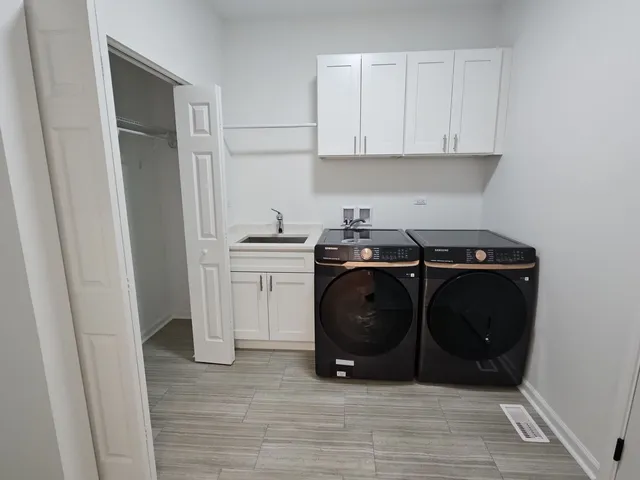 a utility room with washing machine and cabinets