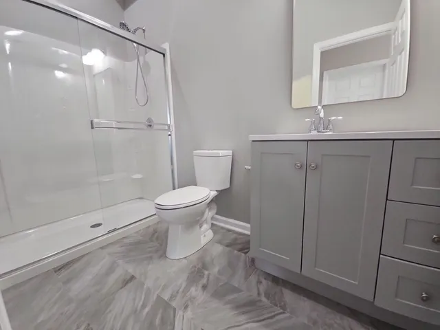 a bathroom with a granite countertop sink toilet and shower