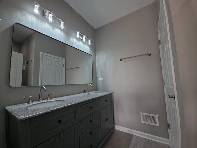 a bathroom with a double vanity sink and a mirror