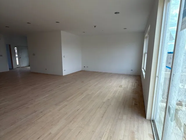 a view of a room with wooden floor and a window