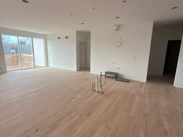 a view of empty room with wooden floor and windows