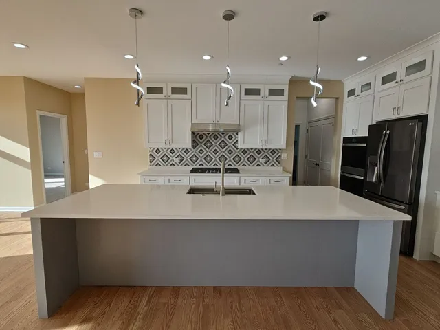 a large kitchen with stainless steel appliances a large counter top