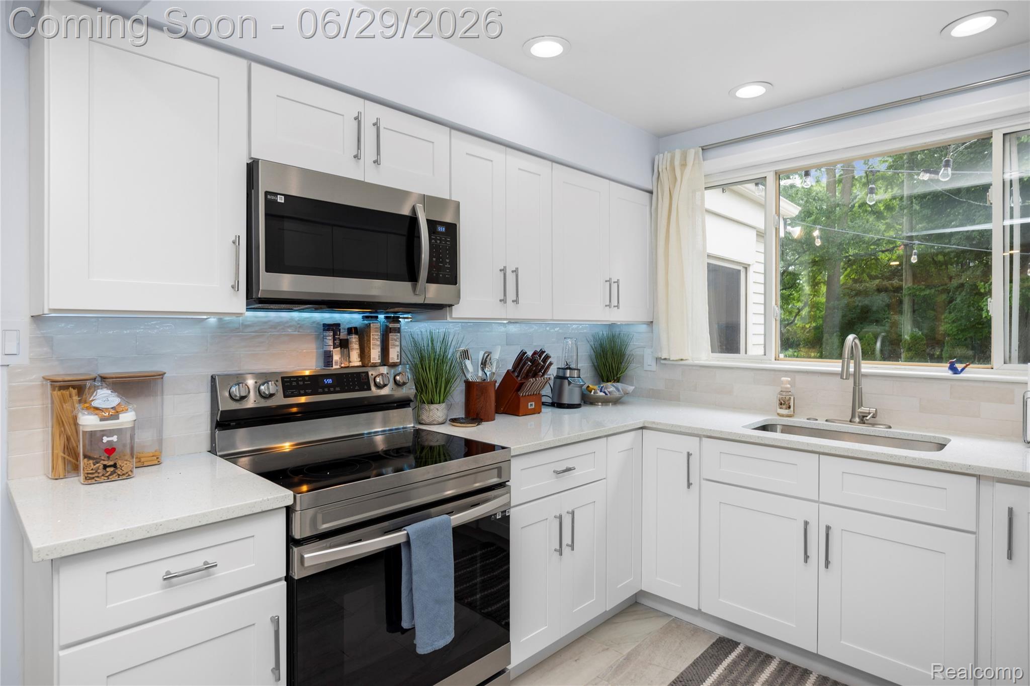 6085 Worlington Road Bloomfield Hills, MI 48301 - Photo 21 of 75 Well-appointed kitchen featuring white cabinetry, stainless steel appliances, light-toned countertops, a tile backsplash, and recessed lighting