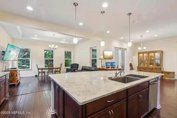 a kitchen with center island a sink appliances and living room view