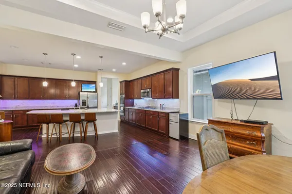 a living room with furniture a flat screen tv and kitchen view