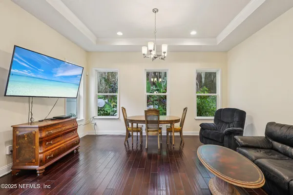 a dining room with furniture a chandelier and wooden floor