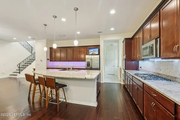 a kitchen with stainless steel appliances kitchen island granite countertop a stove a sink a refrigerator and a oven