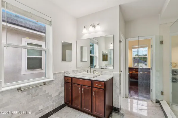 a bathroom with a tub sink and mirror