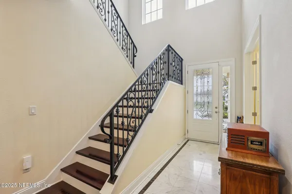 a view of a hallway with stairs and wooden floor