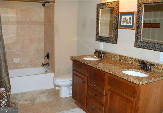 4444 Teen Barnes Road Jefferson, MD 21755 - Photo 27 of 30 a bathroom with a granite countertop sink a toilet a mirror and bathtub