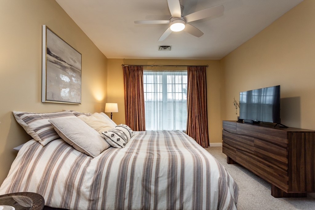 1481 Phillips Road, Unit 1305 New Bedford, MA 02745 - Photo 13 of 34 a bedroom with a large bed and a flat tv screen on dresser