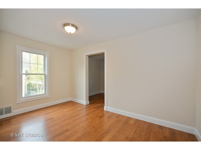 306 Spring Avenue Naperville, IL 60540 - Photo 18 of 25 an empty room with wooden floor and windows