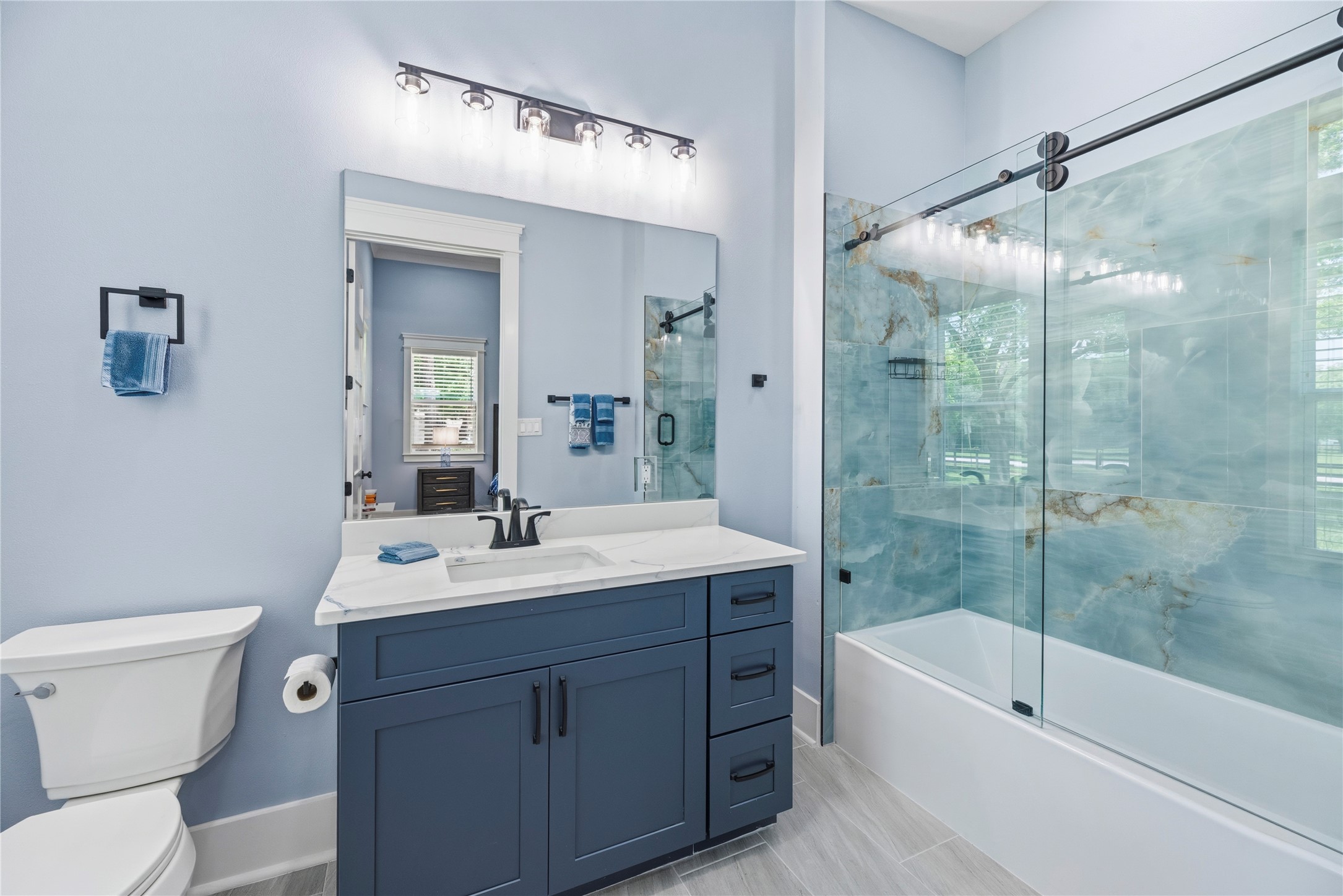 4607 Clayhead Road Richmond, TX 77406 - Photo 22 of 49 Refined full bath showcasing striking stone-inspired tile, custom glass enclosure, and elevated detailing.