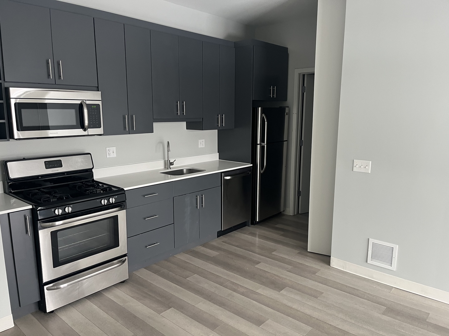 Undisclosed Address Chicago, IL 60647 - Photo 3 of 9 a kitchen with stainless steel appliances a stove a microwave and a sink