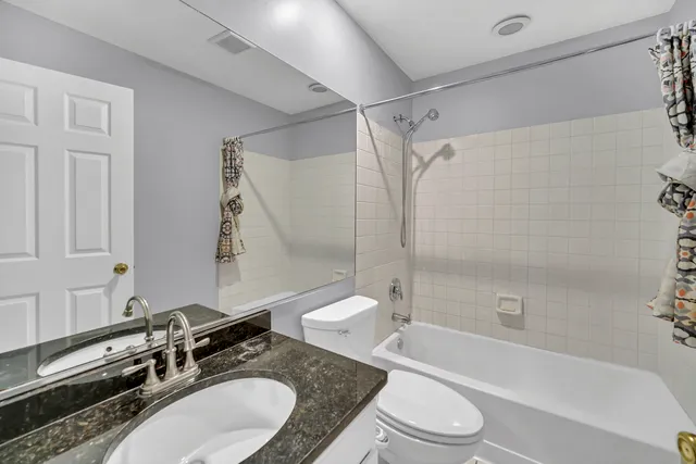 a bathroom with a granite countertop sink toilet bathtub and shower