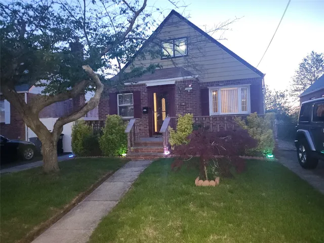 a front view of a house with a garden and plants