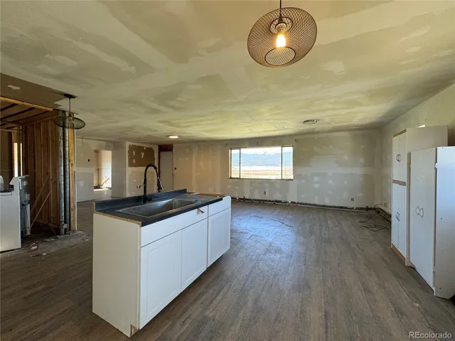 a kitchen with granite countertop a stove and a wooden floor