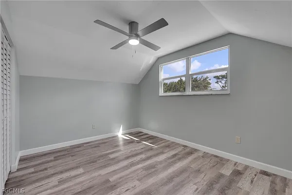 a view of a big room with wooden floor and ceiling fan